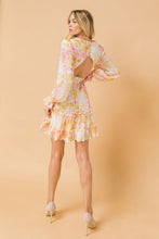 Load image into Gallery viewer, A printed woven mini dress featuring V-neckline with fully lined, ruffled edge, long sleeve with ruffled cuff, waist yoke, ruffled hemline, triangle back cut out with button and zipper closure.  
