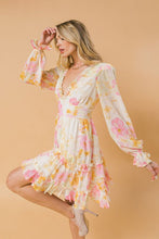 Load image into Gallery viewer, A printed woven mini dress featuring V-neckline with fully lined, ruffled edge, long sleeve with ruffled cuff, waist yoke, ruffled hemline, triangle back cut out with button and zipper closure. 
