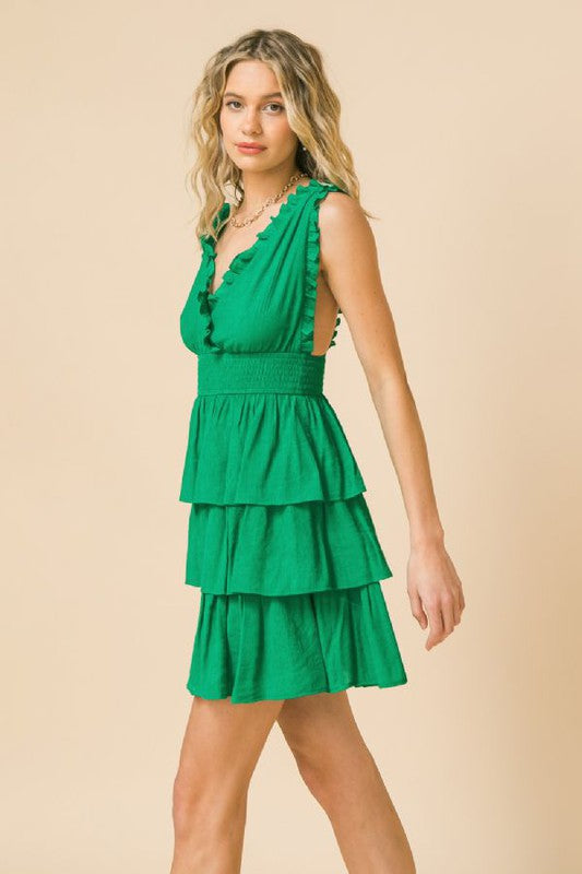 Womens Green A solid woven mini dress featuring 100% polyester lining, surplice neckline with ruffled edge, smocked waist band, layered skirt, plunging back with ruffled straps dress